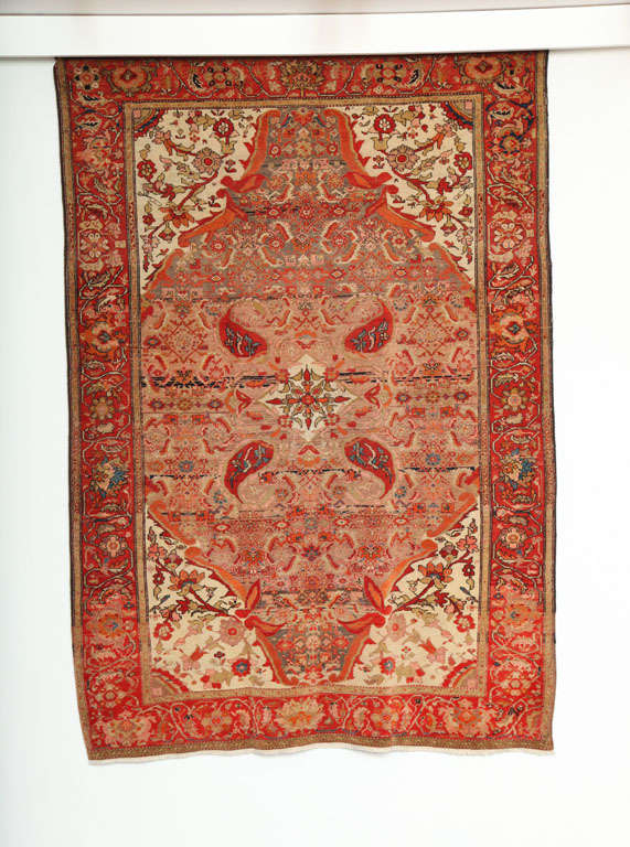 This 1870-1880 Persian Mishan Malayer rug consists of a cotton warp, handspun wool weft and hand-knotted handspun wool pile. Its vivid reds, oranges, pinks, and blues were all created using organic vegetable dyes. The cream, gold and taupe tones
