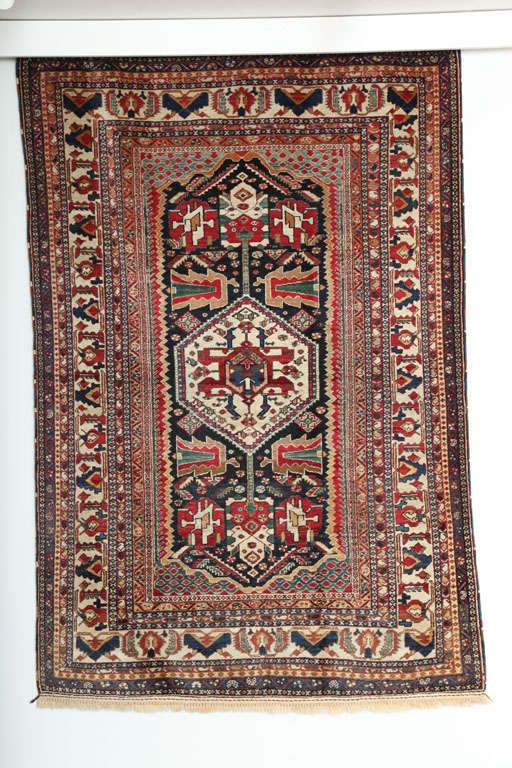 This 1880-1890 Persian Kashkouli Qashqai rug consists of a handspun wool warp and weft and hand-knotted handspun wool pile. Its rich blues, reds, greens, and golds were all created using organic vegetable dyes, and its neutral creams and beige tones