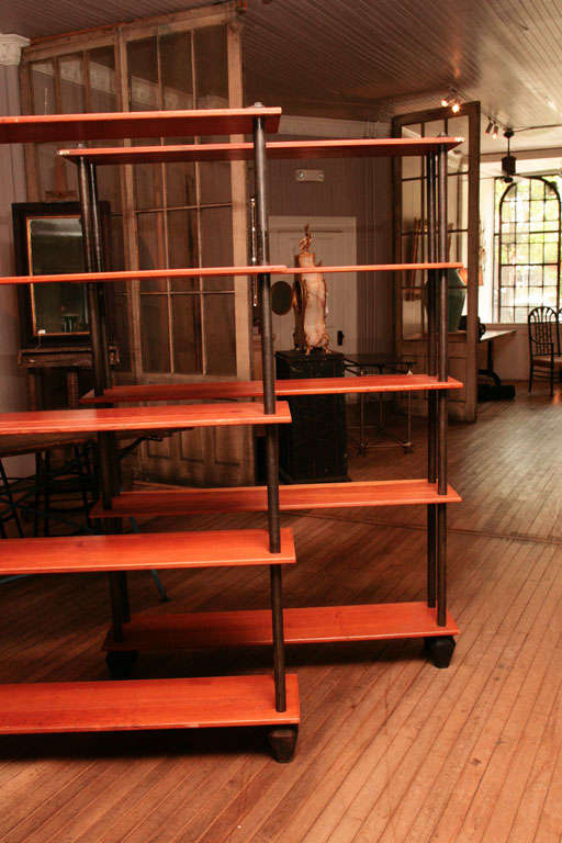 pair of bookcases<br />
five yellow pine shelves<br />
divided with steel rods<br />
set on tapered cubist iron feet