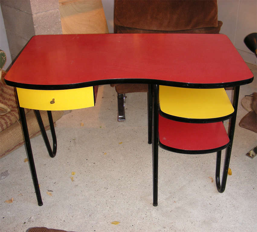 1950s desk with metal legs and multicolored melamine elements.