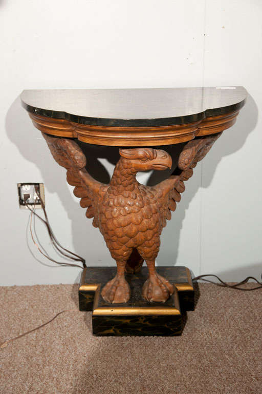 Pair of exceptional solid wooden carved winged eagle consoles. The finely faux painted marble tops supported by carved ball and claw winged eagles. Possibly Horner bros. Sitting upon faux painted marble bases.