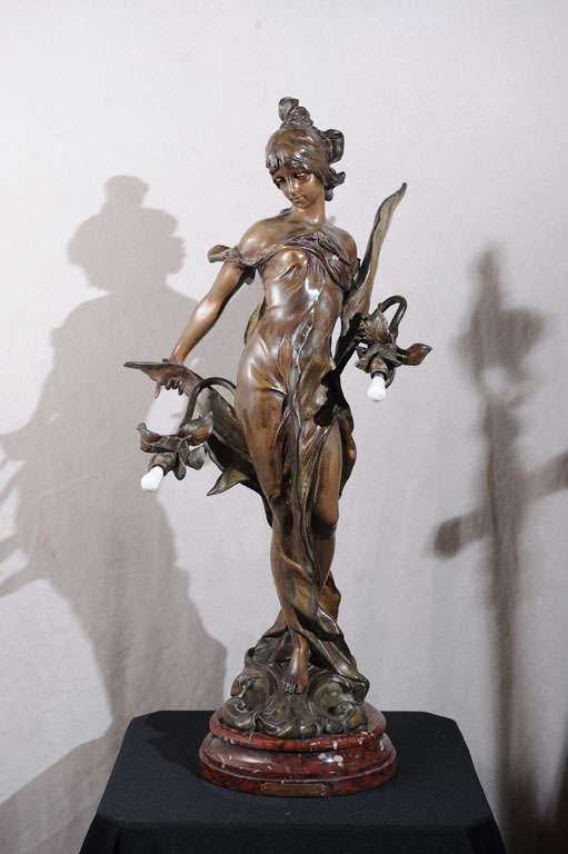 This very large and sensuous sculptural lamp is quite a magnificent piece.  The woman is very beautiful and the graceful pose with all the thickly cast leaves make this a piece worth owning.  Can be used as a newel post.  Mounted on a beautiful