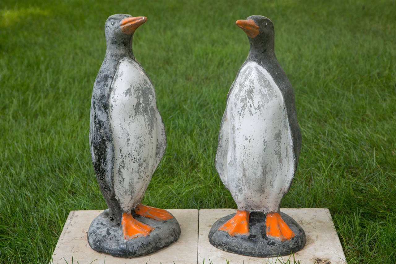 A set of two identical composition stone penguins, each with old polychrome.