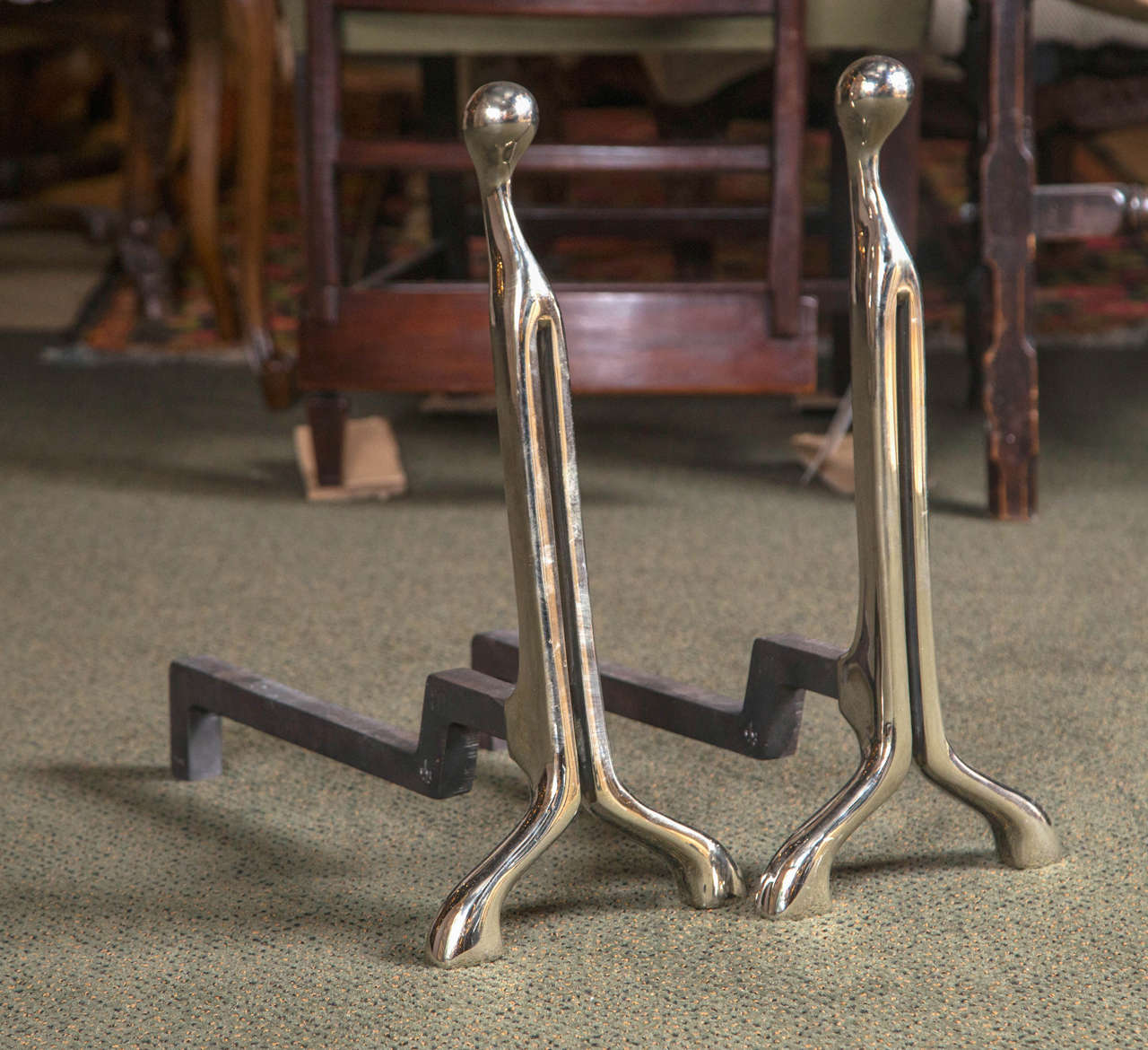 A marked pair of modernist andirons in polished nickel by Virginia Metalcrafter.