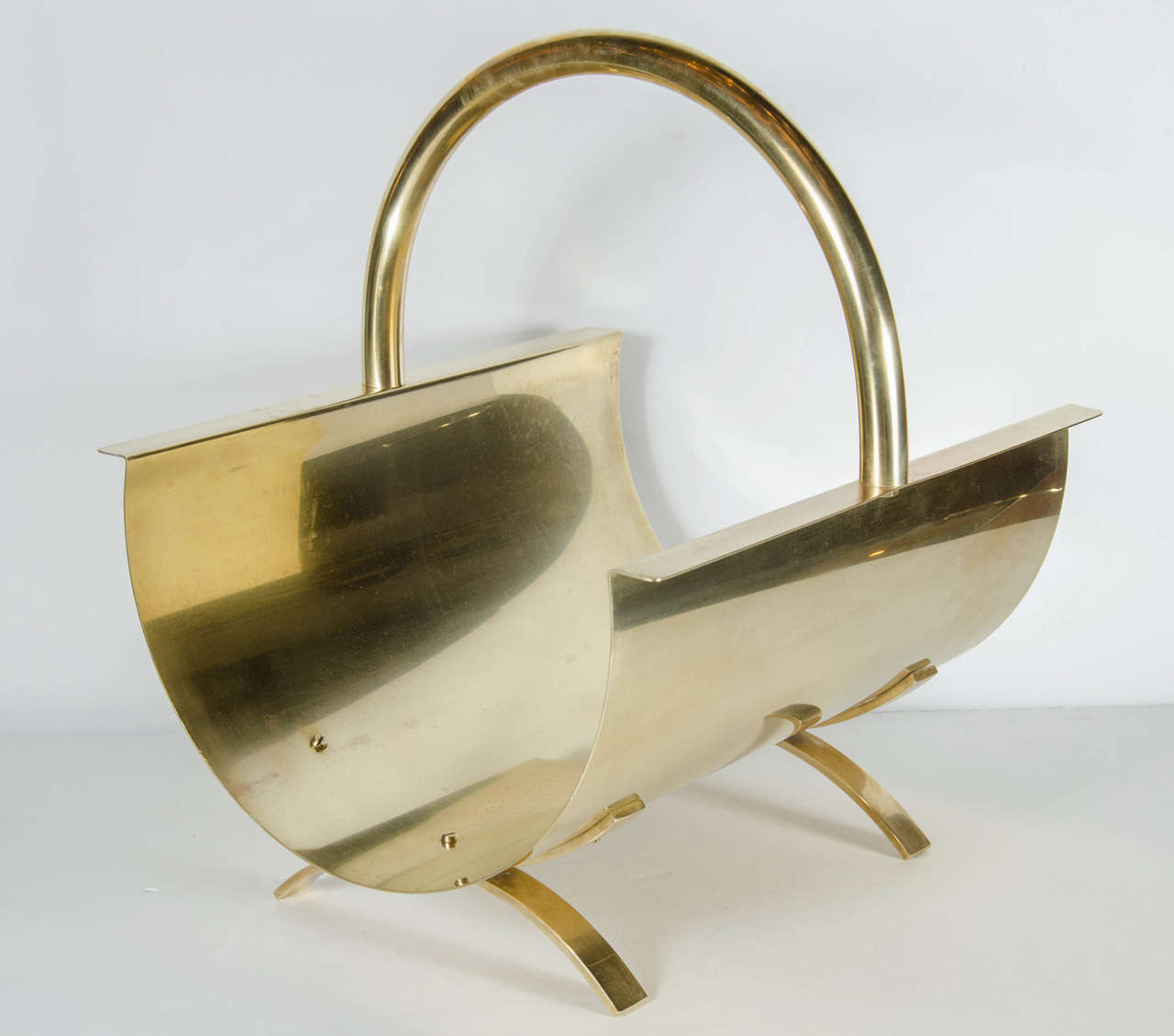 This outstanding Mid-Century Modernist log holder features a strong crisp geometric design made entirely of brass. This stunning piece can also be used as a magazine stand and is in excellent condition.