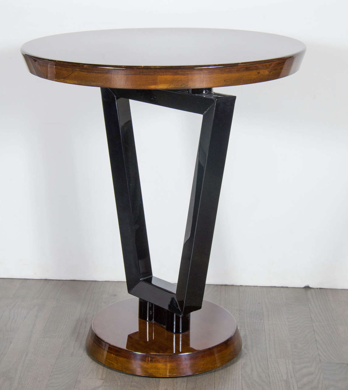 This very sophisticated Art Deco Streamlined occasional or side table features an interesting geometric angular support in black lacquer, the table top and base are book-matched walnut. Restored to mint condition.