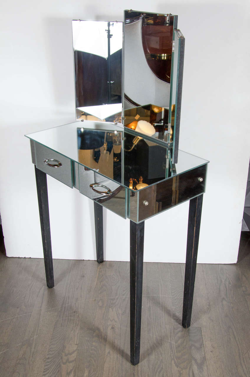 This gorgeous mirrored vanity comes complete with two drawers with chrome pulls, a demountable tri-fold mirror that enables the user to see a 180 degree view and slim-line ebonized walnut legs with plenty of space for a chic matching stool (see our