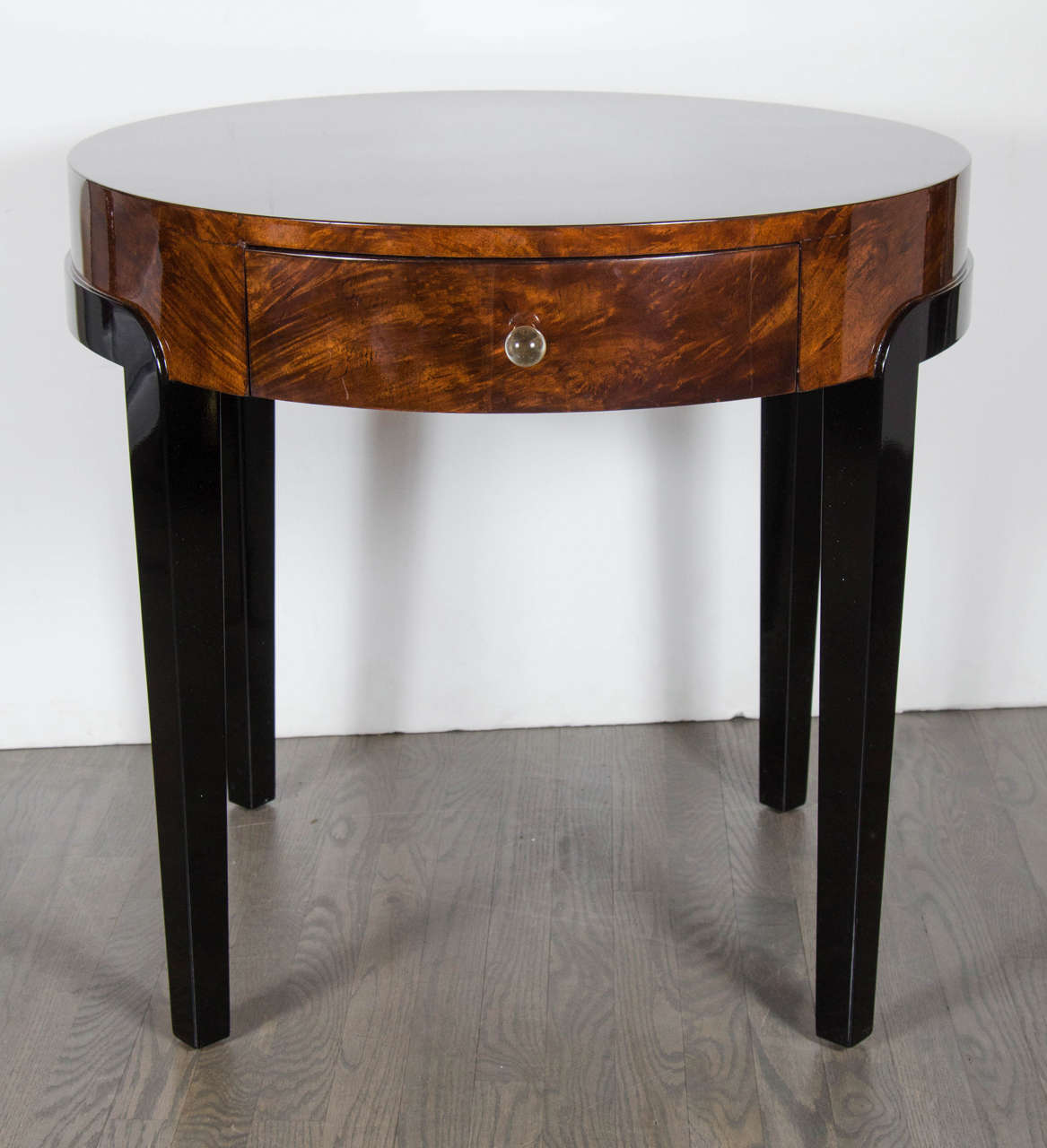 This stunning table features streamlined supports and legs in black lacquer with a book-matched exotic walnut top fitted with two drawers and crystal pulls.This table has been mint restored.