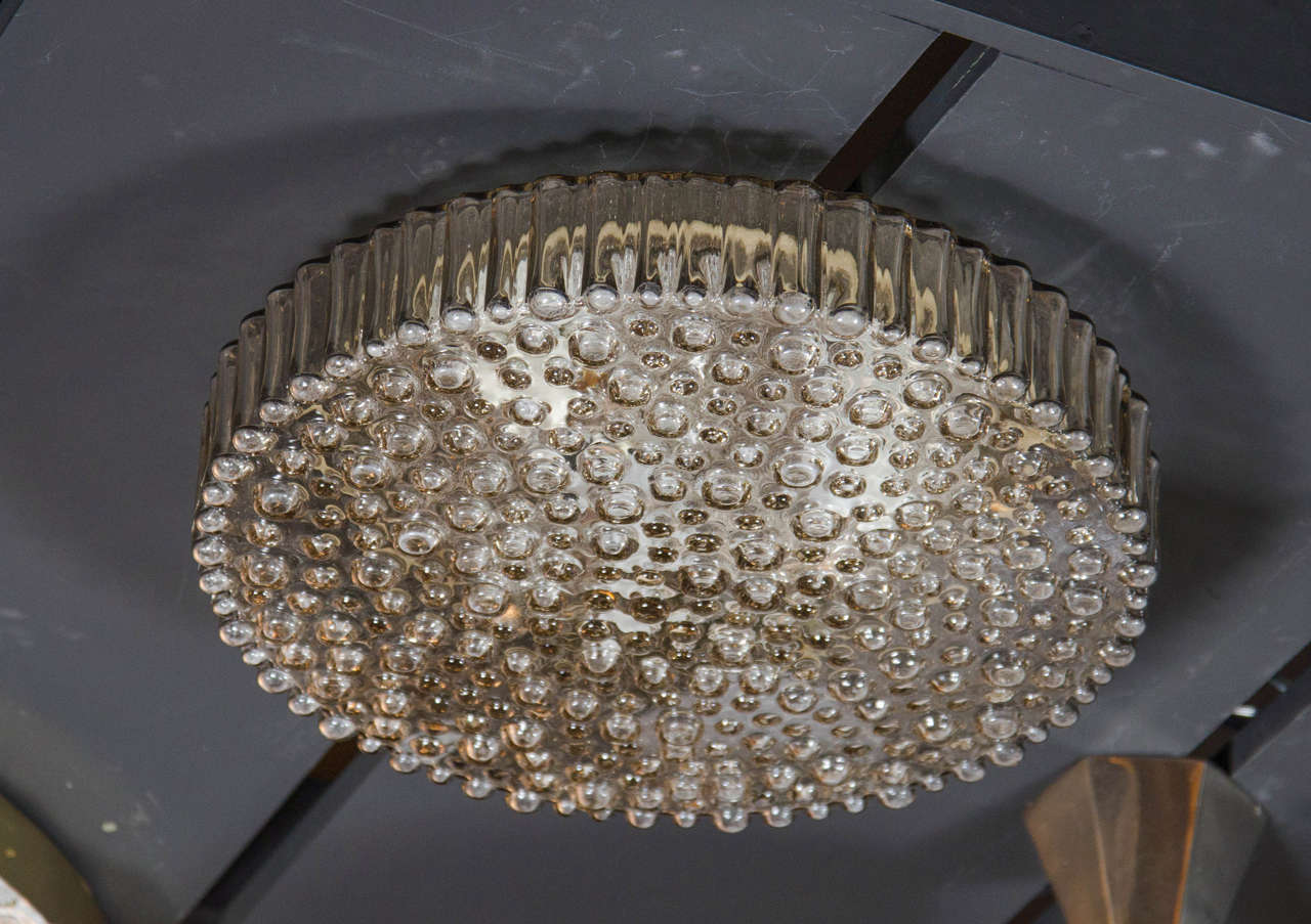 Mid-Century Modern flush mount chandelier by Glashutte Limburg.  This chic flush mount features a shallow, hand-blown glass shade with a unique bubble glass motif that mimics raindrops.  The glass shade also has a hand-blown outside surround with