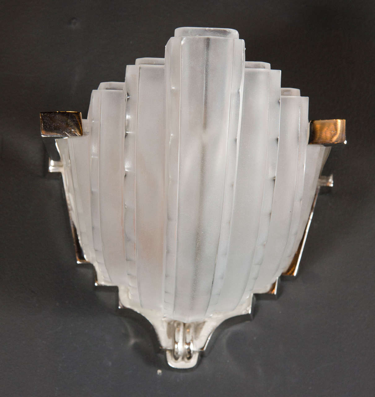 Exquisite pair of Art Deco Skyscraper Style sconces by Sabino.  These beautiful wall sconces feature a polished nickel frame with a multi-tiered, Skyscraper Style design and fluted centerpiece.  The frosted glass shades rest atop the polished nickel