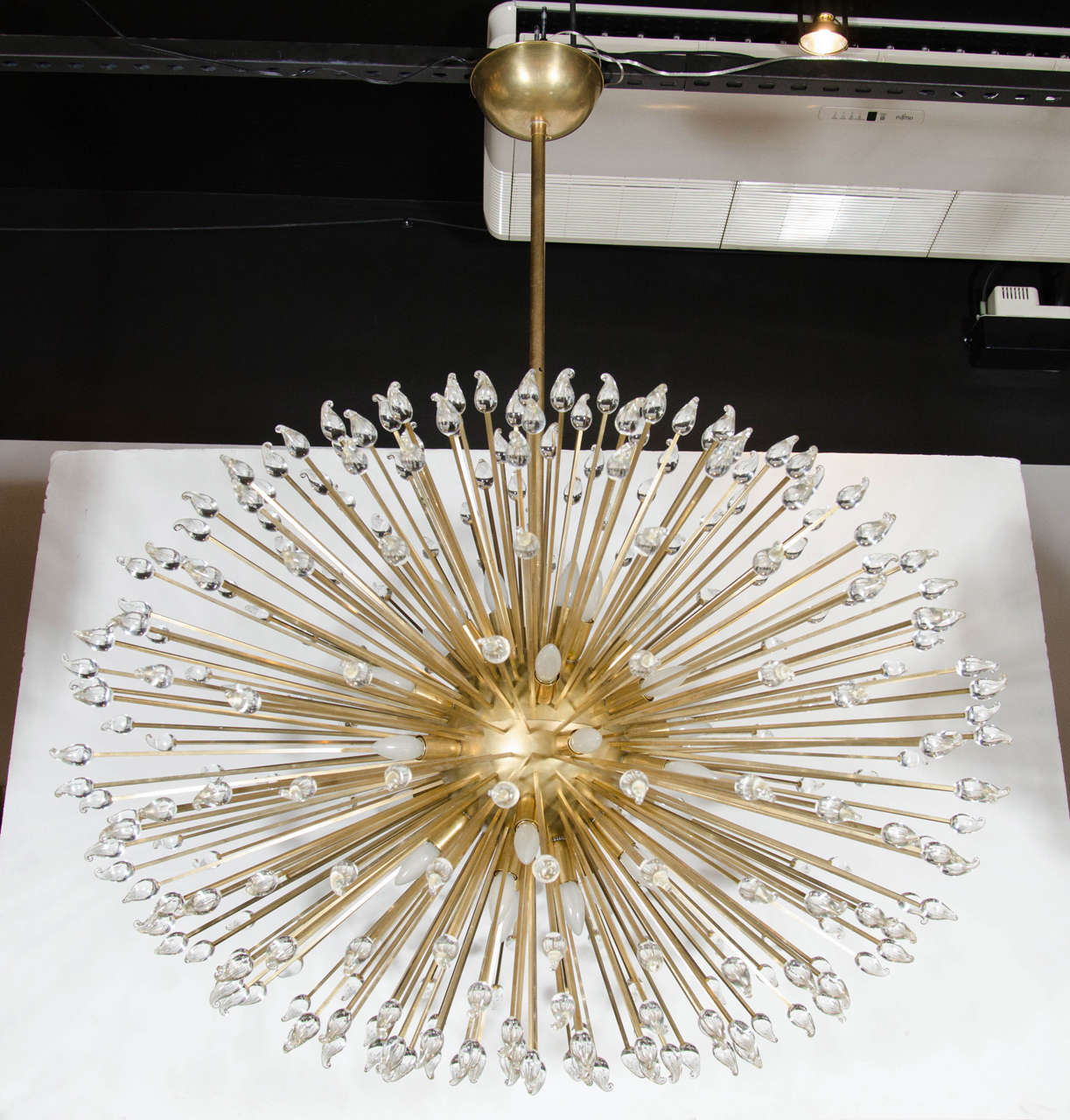 Mid-Century Modern sputnik chandelier consisting of numerous brass rods that extend from its brass center point where each rod is individually adorned with handblown Murano glass teardrop shaped finials that give this chandelier its beautiful,