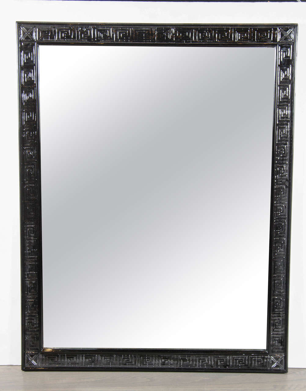 This chic Mid-Century Modern mirror features a repeated greek key design on a slim-line border finished in black lacquer. The mirror can be hung horizontally or vertically. Restored to mint condition.