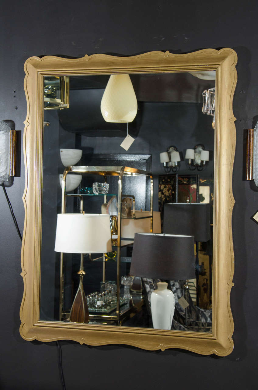 Exquisite Mid-Century mirror in hand-carved wood with Classic and elegant scallop design. The mirror has hand applied gilt leaf finish in matte, and can be hung from vertically or horizontally.