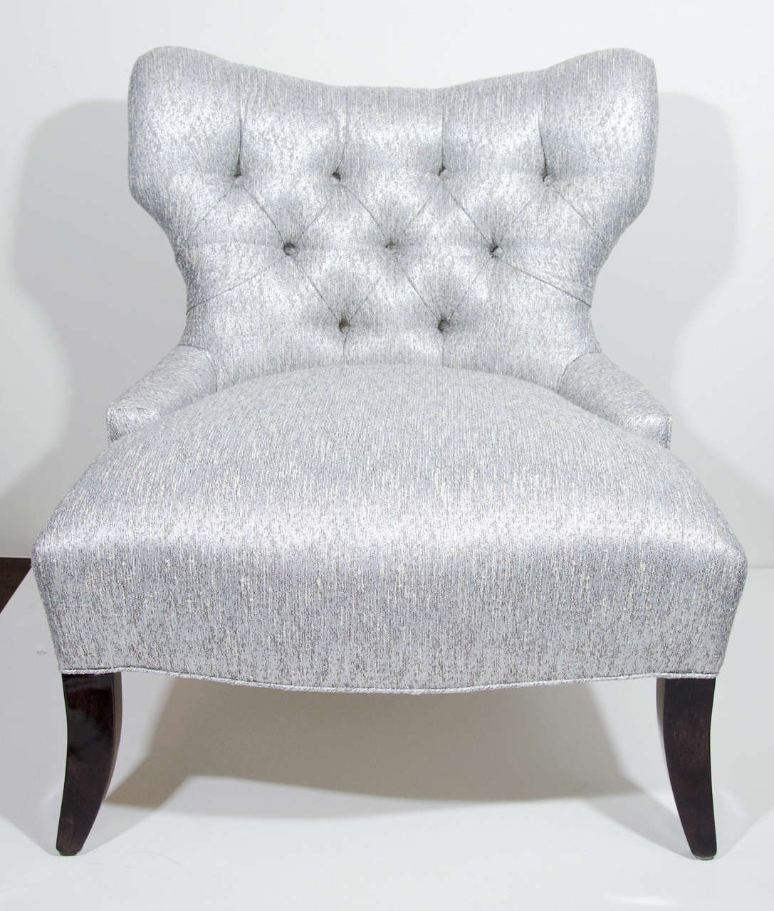 Elegant slipper chairs with shield back design and tufted details.  
Newly upholstered in a metallic grey and ivory boucle fabric with woven platinum fibers and with splayed ebonized walnut legs. The subtle curves combine to make this piece