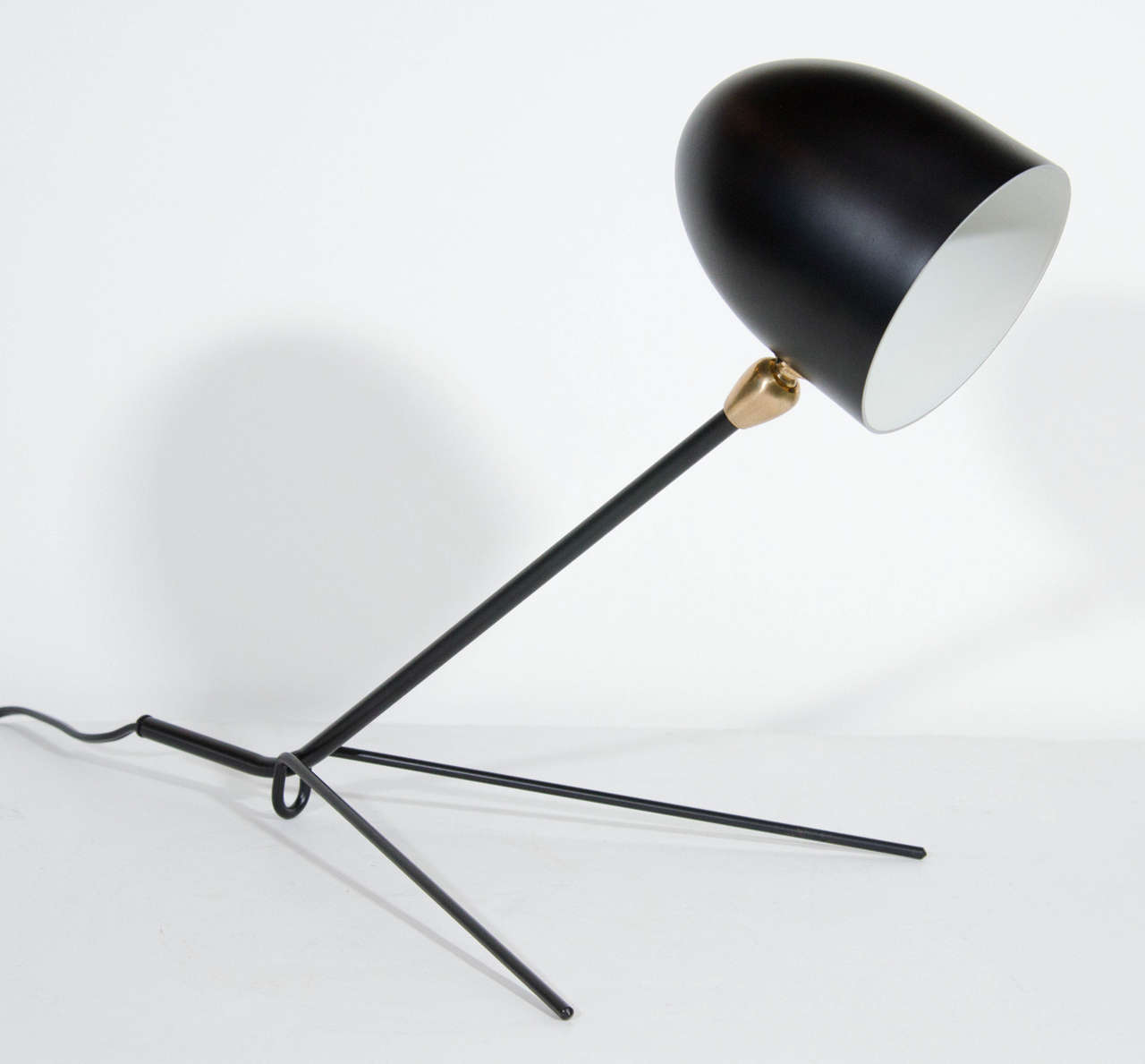 Outstanding modern table lamp with sculpted form in satin black enameled aluminum and iron. The lamp has pivoting shade with stylized brass fitting. It features a leaning stem design with and 