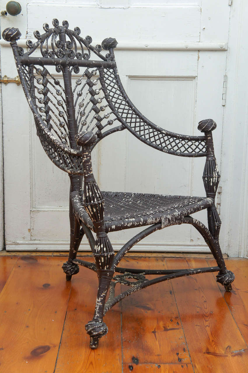 Intricately woven brown painted 19th century Heywood-Wakefield three
legged corner wicker chair.