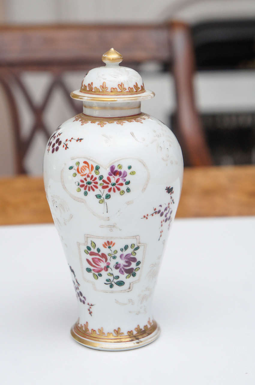 Samson porcelain vase with lid, circa 1900. Baluster form with white floral decoration, scrolls and gilt. Iron-red trim.