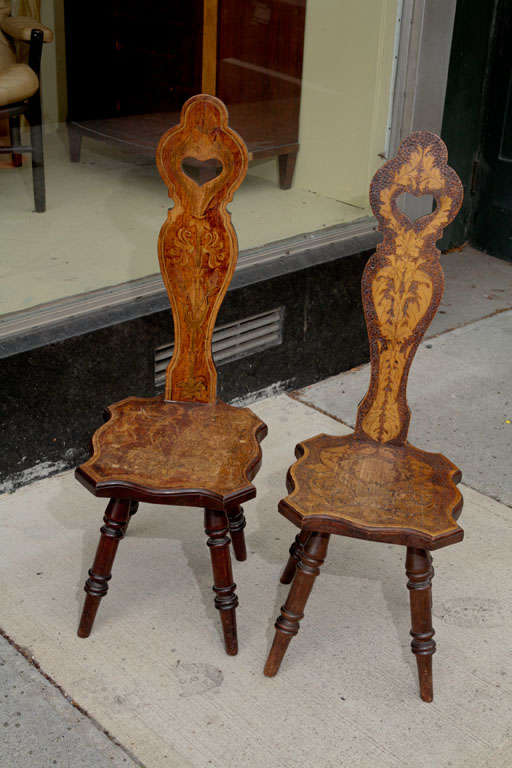 Pair of Art Nouveau period hall chairs, in oak, decorated individually, one with penned corn and chrysanthemums, the other with oak and maple leaves and burnt in seed design, turned legs