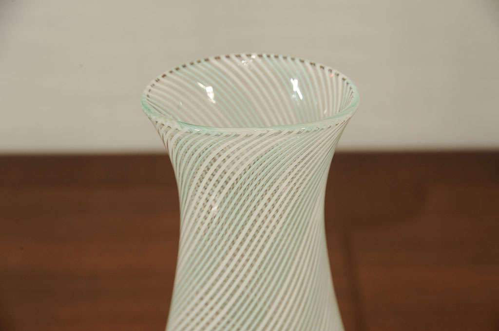 Handblown vase of clear glass with pale green and white swirled stripes alternating in rows of five. Applied foot with gold inclusions.