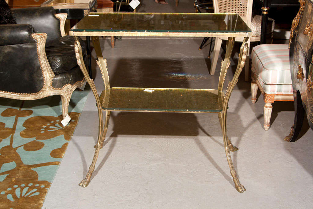 A French Directoire style bronze stand with two gilt-glass tops, supported by curved bronze legs ending in ram feet. Stand is slightly wobbly. 