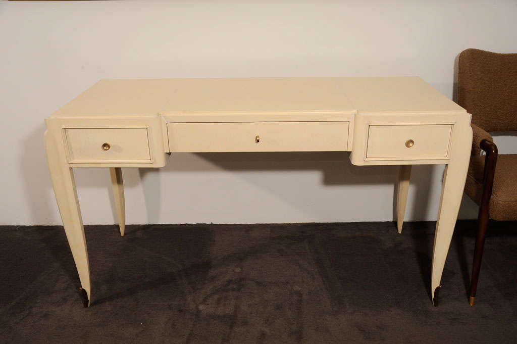 Fine parchment covered rectangular Desk by Jean Pascaud (1903-1996), opening with three drawers, with gilt-bronze pulls and sabot.   <br />
<br />
See Le Mobilier Francais by Y. Brunhammer p. 111, Massin Ed.<br />
for a Cabinet with similar