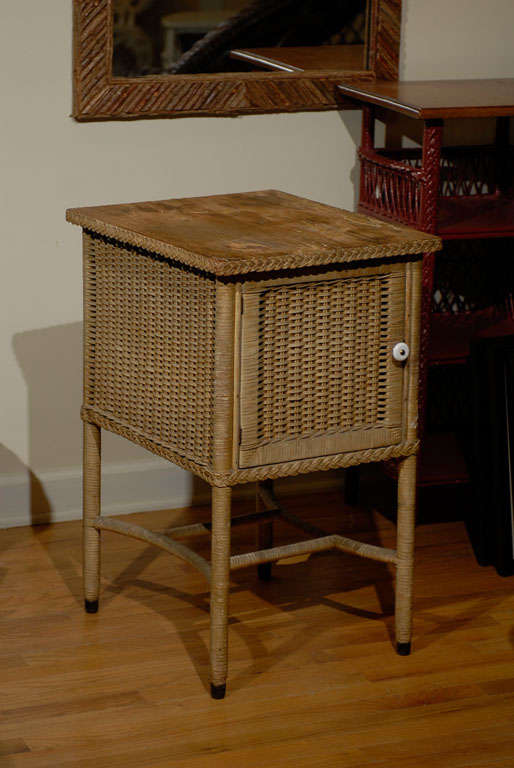 This is a very handsome side table by Heywood Wakefield.  It is painted.  The door opens to a large cavity.  There is a braid around the top of the table and the bottom.  The legs are joined by a lovely stretcher.  This is a beautiful piece of