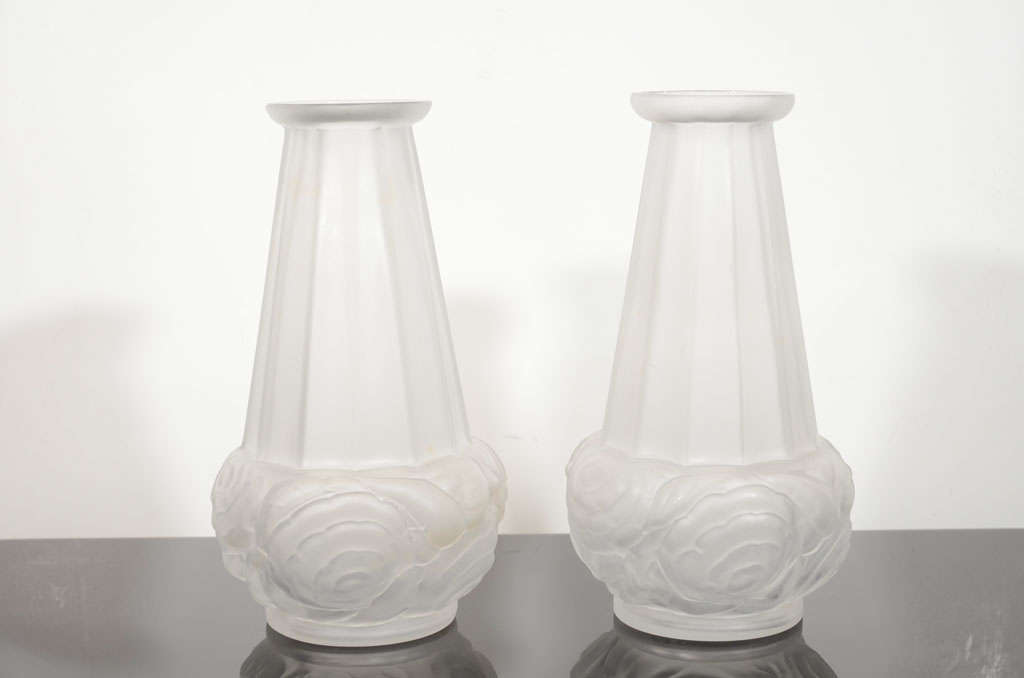 This elegant pair of Art Deco vases were handblown by the illustrious French glass atelier Spaivet, circa 1935. They feature a circular bobeche top; a neck composed of 12 channelled sides with ridged seams where the planes adjoin; and high style