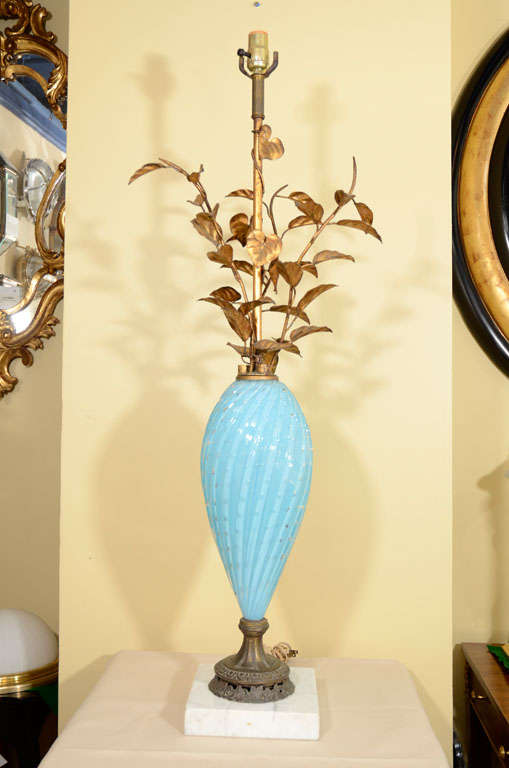 Pair of tall vintage blue Murano table lamps with gilt tole foliate motif on top, mounted on square marble base.<br />
42