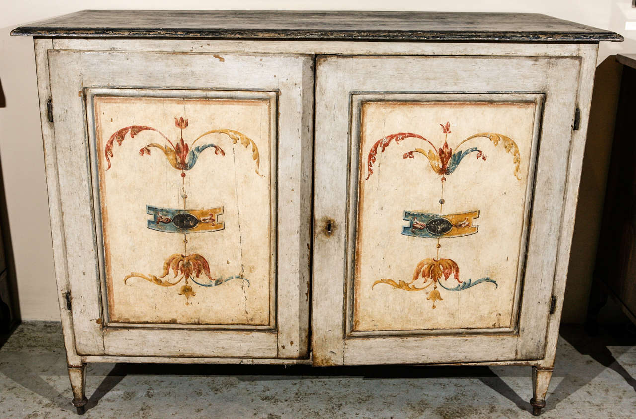 Large, hand painted, two-door Tuscan buffet in old wood- circa 1850. The inset panels feature whimsical flags capped both top and bottom by scrolling foliate embellishments. Side panels painted in a similar manner.