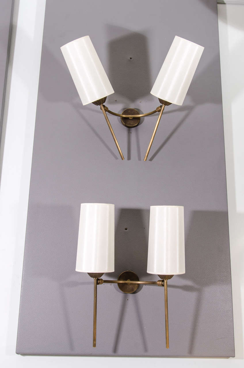 Pair of classically designed French sconces updated with articulations. The sconces can hold a variety of angles and positions. Refinished brass with silk shades.