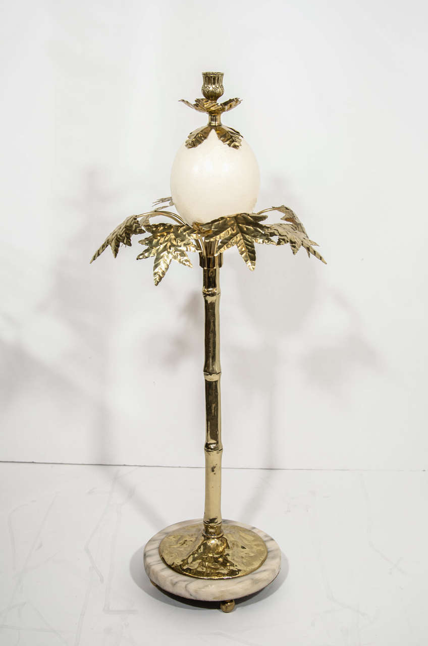 Exceptional large candlesticks with stylized palm tree design 
in hand crafted and hand forged brass. The candlesticks feature an exotic ostrich egg amid leaves and branches. The candlesticks also feature exotic polished marble bases in hues of
