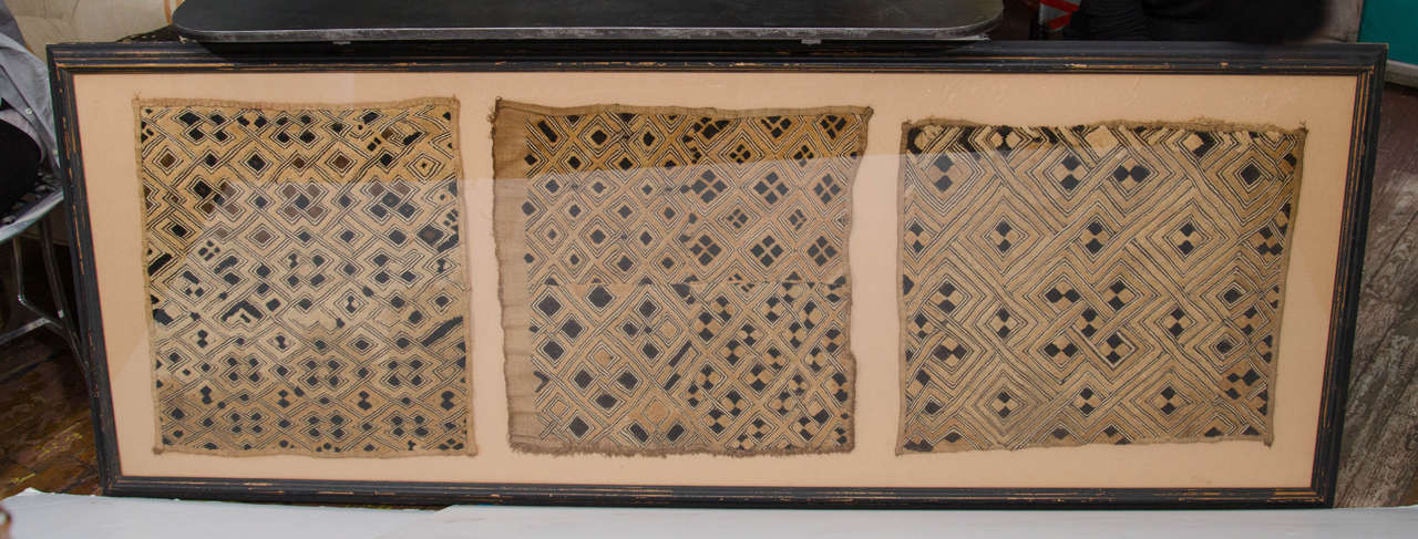 Framed African Kuba cloth in three sections.