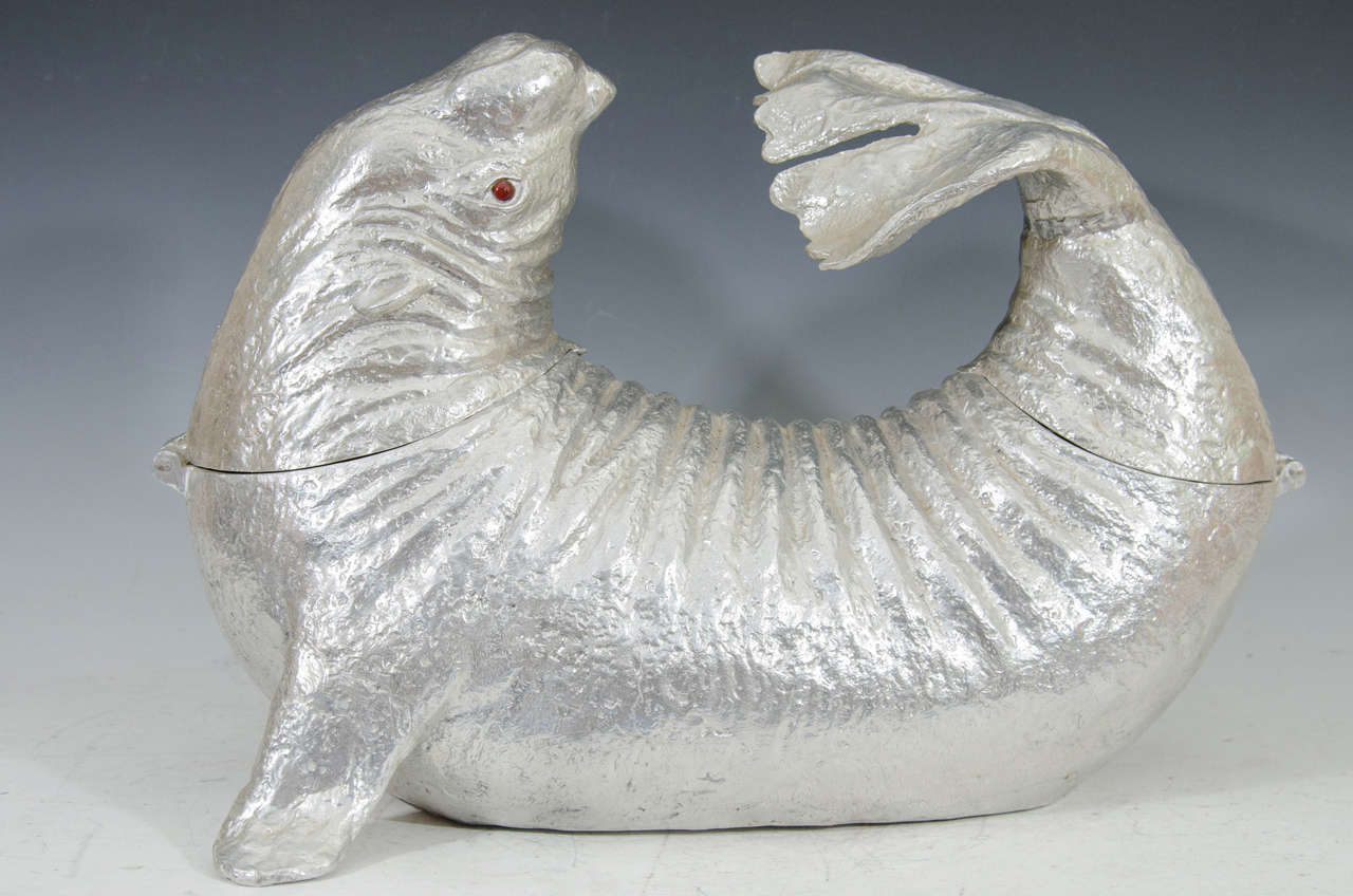 An Arthur Court sculptural aluminum sea lion ice bucket or wine cooler with red eyes. The piece is hinged at its head and tail.

Please see our other Arthur Court wine coolers, ice buckets, and serveware. We have elephants, dolphins, wild boar,