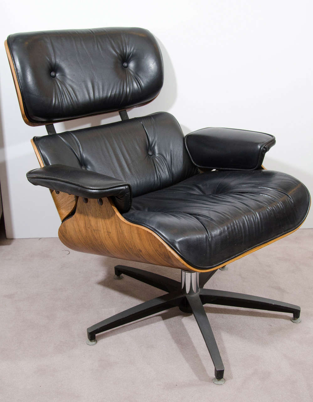 A vintage classic Charles and Ray Eames for Herman Miller style lounge chair and matching ottoman in black leather and walnut.

Good vintage condition with some wear to leather.

Dimensions for chair: 34