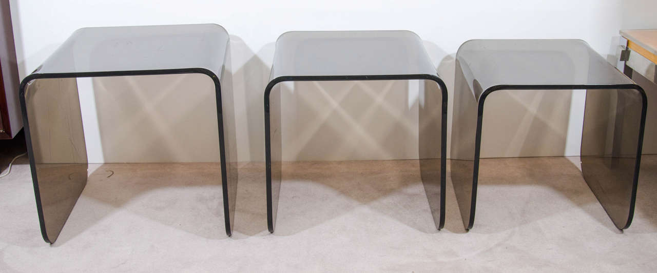 Great set of Three Waterfall Smoky Quartz color Lucite nesting or stacking tables, circa 1970s. Versatile in Form and Function for many Modern Interiors.Substanially Cast and Formed Tables.
Dimensions: 
17