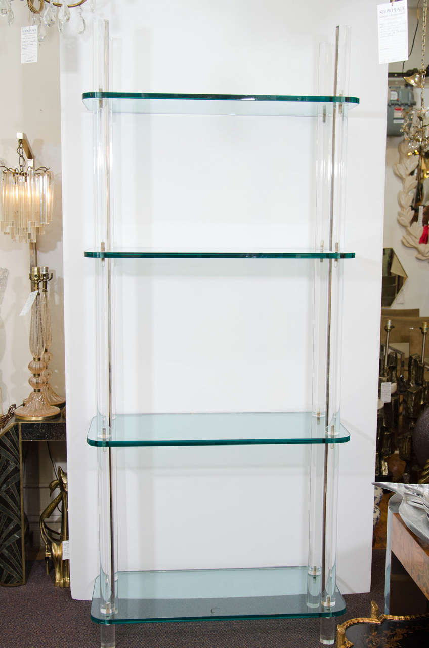 A vintage sturdy bookcase or bookshelf made of Lucite with thick glass shelves.