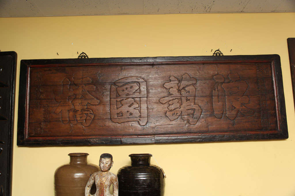 Dieses antike chinesische horizontale Schild aus dem 19. Jahrhundert zeigt in Holz geschnitzte chinesische Schriftzeichen in einem prächtigen kalligrafischen Stil. Der Rahmen ist mit roter und schwarzer Originalfarbe bemalt und hängt an zwei feinen,