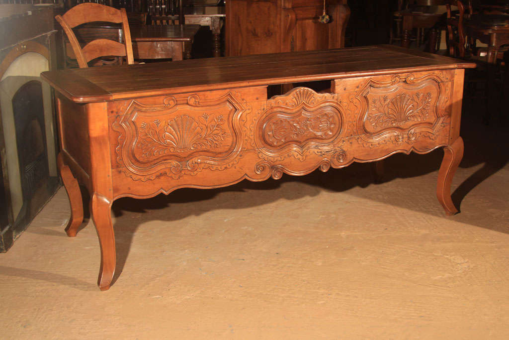 French Cherry Bureauplat Desk from Renne, France.  Handcarved with French Cabriole Legs.

The back of the desk is very plain with a large knee hole. There are two large drawers on each side (total of 4 drawers).

This type of carving is typical