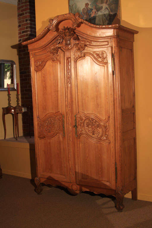 French Pine Marriage Armoire from Normandy with beautiful carving.  

Original carved top bonnet and lovely carving of wheat basket.

Medium Pine color. Three replaced shelves inside.