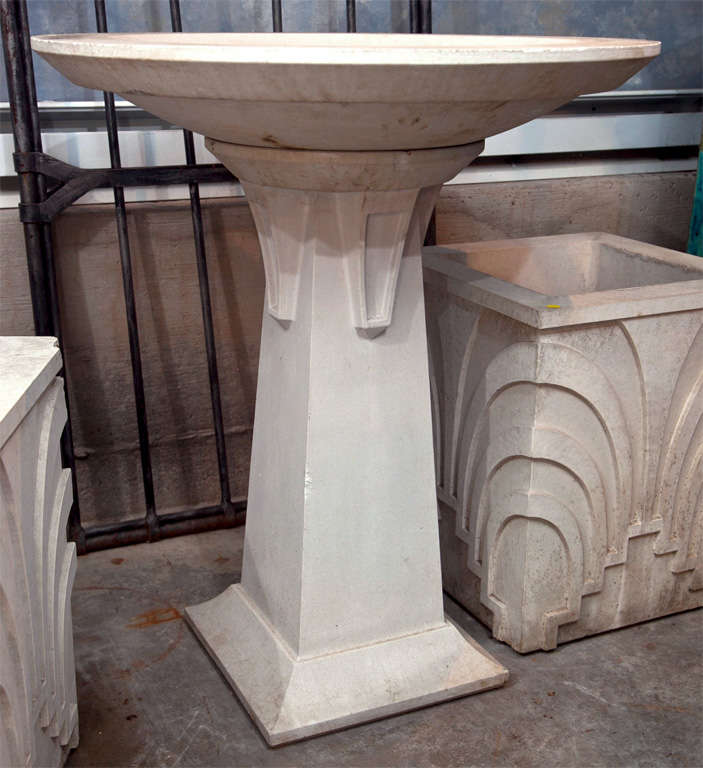 Grand, imposing, and totally glam Deco in style, this tall cast stone birdbath makes the perfect contemporary statement in your garden. Made of a very heavy cast stone with a smooth, creamy white finish, this piece is lightly weathered and has a