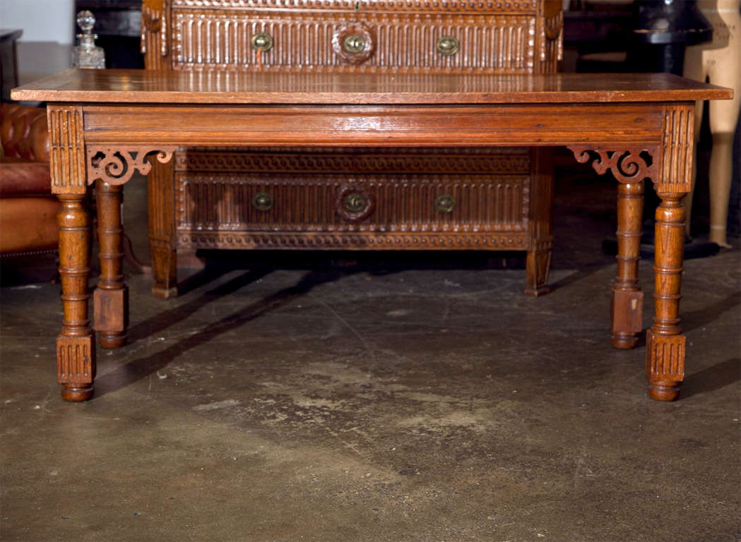 Flemish oak table, c. 1840, in the baroque style with vase and block turned legs and pierced corner brackets to the apron. This table makes a supert writing or library table.