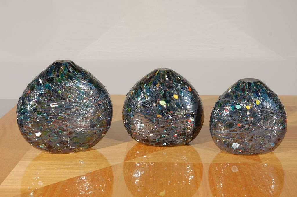 A graduated set of three art glass vases. Predominant color is black with colored flecks. Sizes are:

7