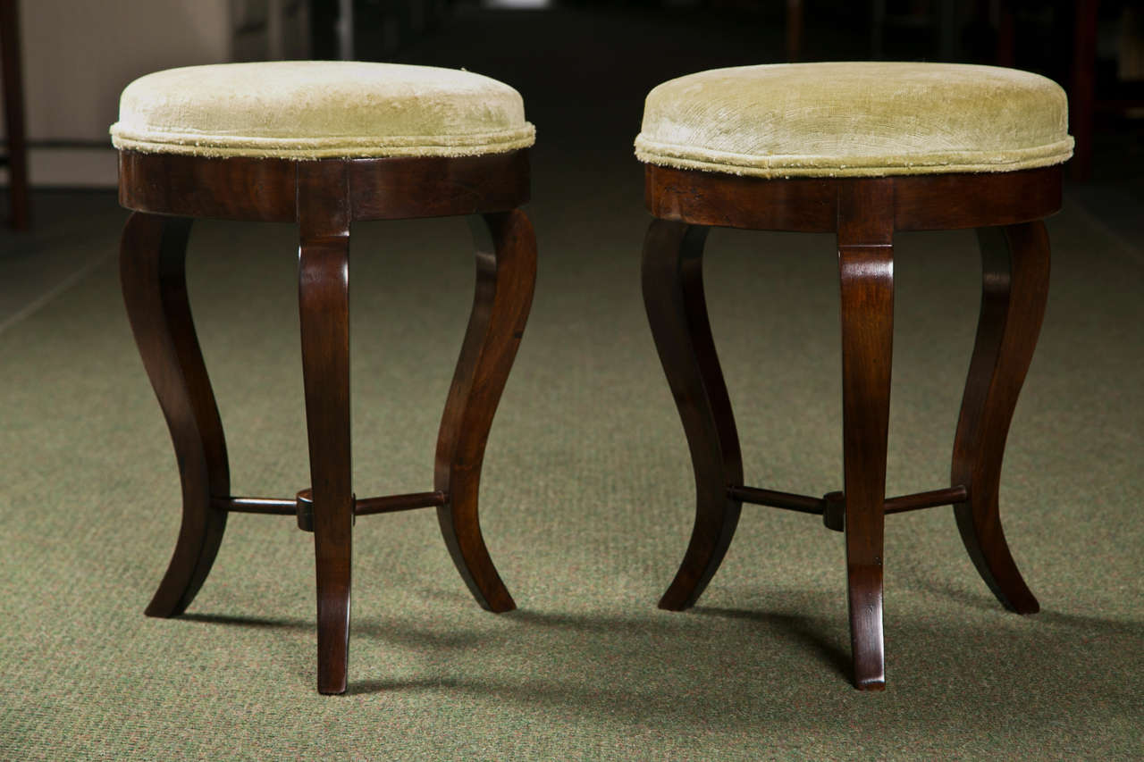A pair of Italian, three-legged, neoclassical stools.