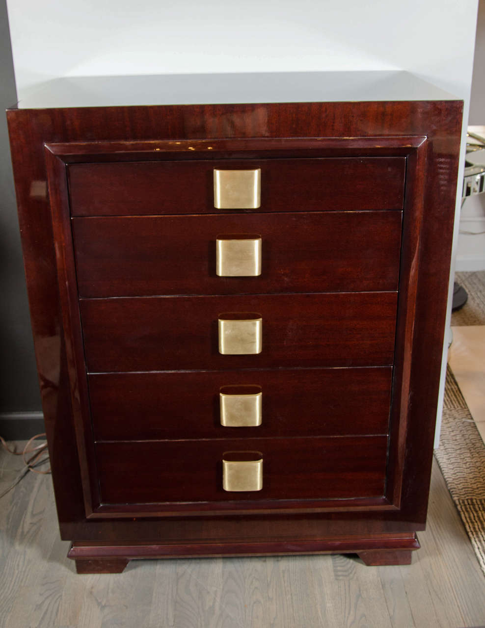 This sophisticated Mid-Century Modern high chest was realized in the United States, circa 1950. It offers an austere rectangular form in beautiful bookmatched mahogany with a total of five drawers, offering a wealth of storage possibilities. Each