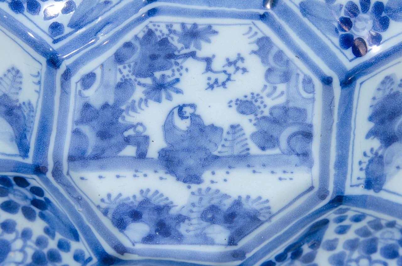 A late 17th century Hanau faience (delft) blue and white charger: octagonal, lobed and painted in the Chinese transitional style of the period. It is decorated in cobalt blue with a central cartouche showing a figure seated in a garden bordered by