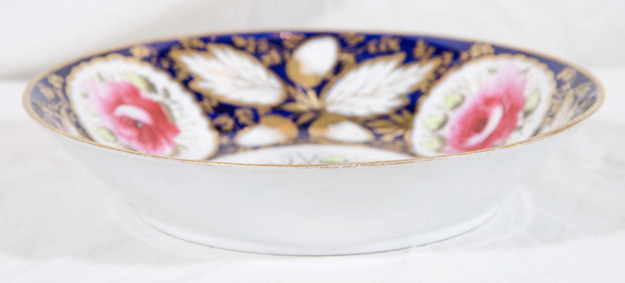 We are pleased to offer this pair of antique English porcelain deep dishes hand-painted in beautiful cobalt blue and decorated with large, bright pink roses, and lavishly gilded oak leaves. Attributed to New Hall circa 1820 this pair will add