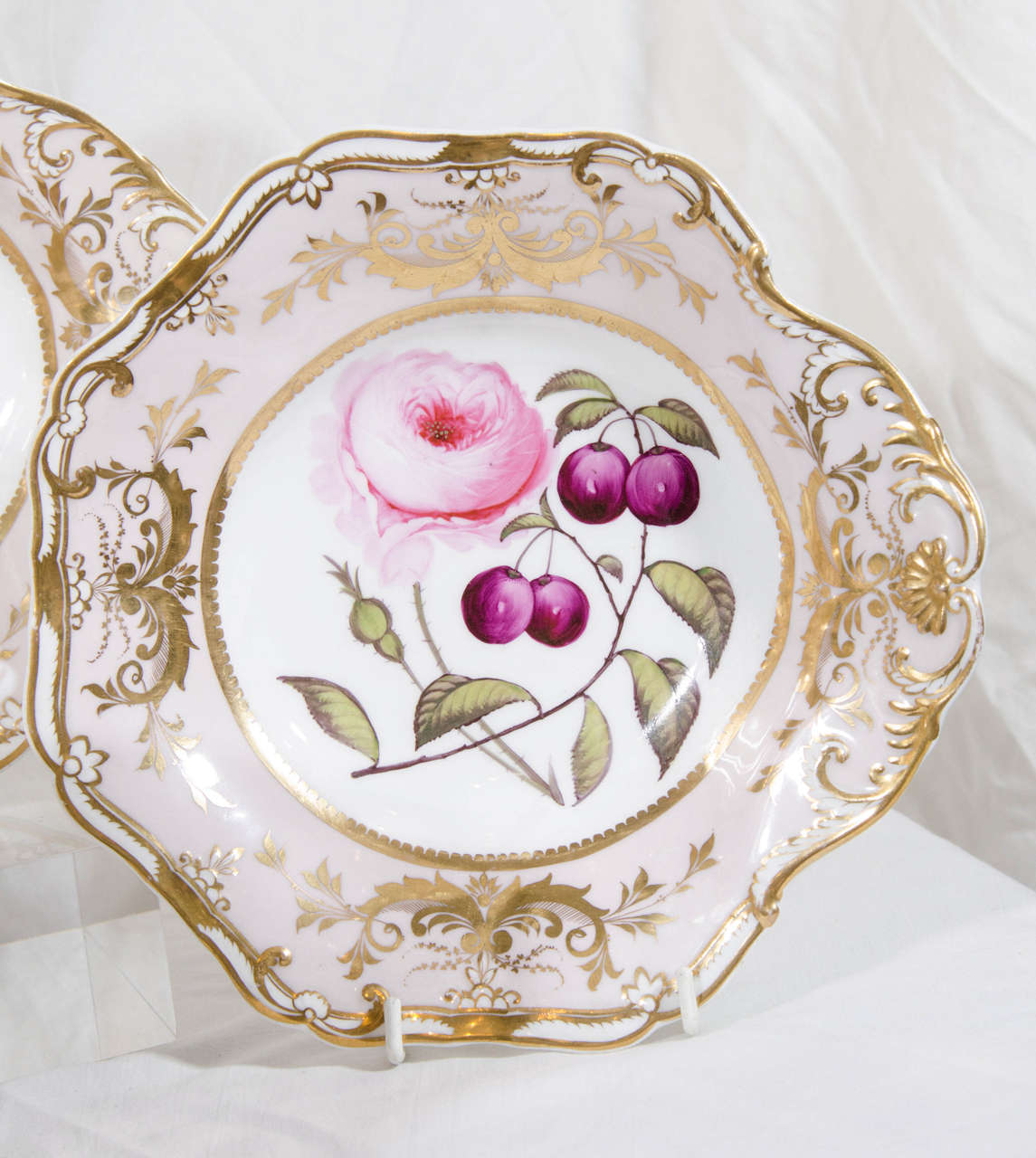 A lovely large oval shaped centerpiece decorated with well painted fruits, flowers and lavish gilt  (see image #7 for an image of the interior). Together with four matching shell shaped dishes. The centerpiece measures 14.25