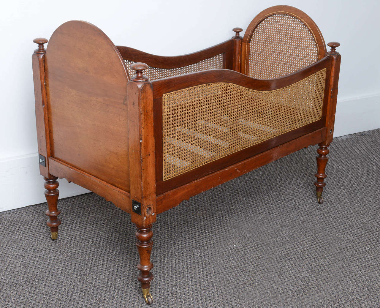 Very nice solid mahogany babies cradle. It's in very good condition the one side goes down to place the baby inside, there is cane to either side and the end which is in perfect condition. It sits on round solid brass castors, it's really a rare