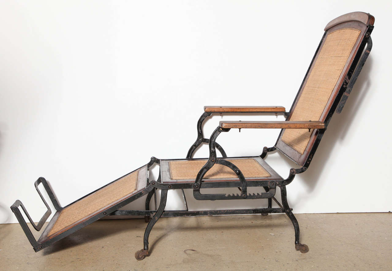 Adjustable Walnut and Black Iron Chaise Lounge Chair designed by Cevedra Sheldon for Marks Adjustable Folding Chair Company of New York. Late 19th Century. Constructed with Black Cast Iron base, frame and legs, Walnut frame, Cane seat, back, leg