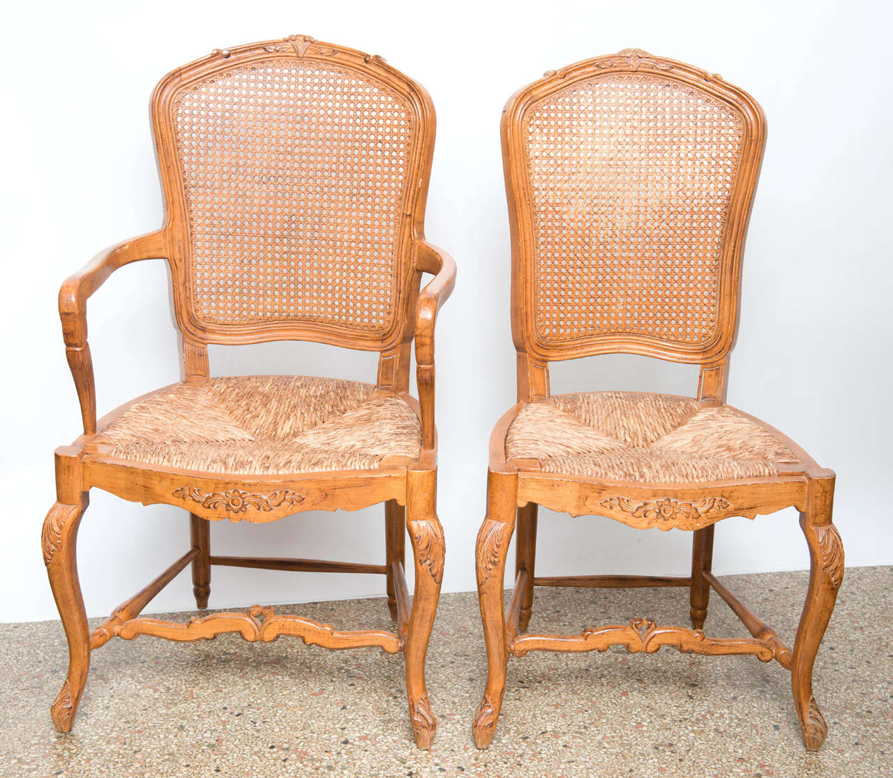 The set consists of 2 arm & 4 side chairs.  Beautifully executed with fine carving of the backs, legs & stretcher.  Rush seats & canned backs, original restored finish

Sides:  21w x 21d x 39.5h

Arms:  22.5w x 23d x 39.5

Originally $ 2,500.00